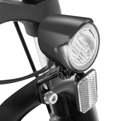 Close-up of a bicycle headlight and reflector on a white background